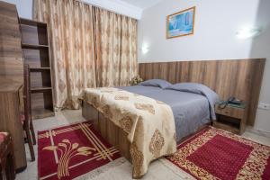 een slaapkamer met een bed en een boekenplank bij Hôtel le passage in Tunis
