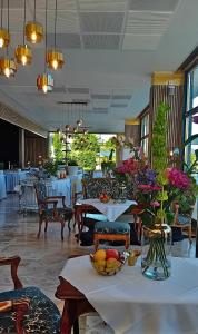 フェルデン・アム・ヴェルターゼーにあるTennis & Yacht Hotel Veldenのテーブルと椅子、花のテーブル付きレストラン