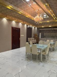 uma sala de jantar com uma mesa e cadeiras e um lustre em سرايا الياسمين em Ilbaras