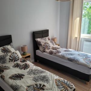 two beds sitting next to each other in a bedroom at NATURA apartament in Malbork