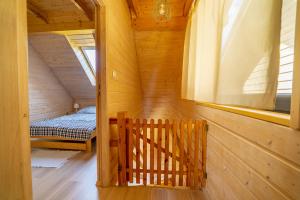 ルビャトボにあるDomki letniskowe Marengoの木造の客室で、ベッド1台、窓が備わります。