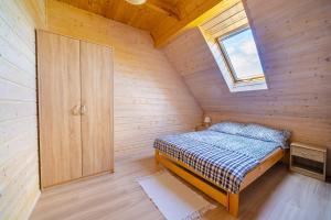 a small bedroom with a bed and a window at Domki letniskowe Marengo in Lubiatowo