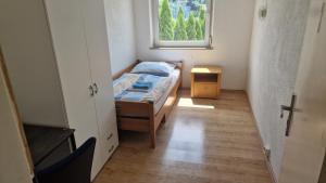Rooms & Apartments Schwäbisch Gmünd في شفايبيش غموند: غرفة نوم صغيرة بها سرير ونافذة