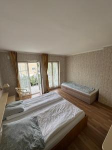 a large bedroom with two beds and a window at Hotel Seeschau in Reichenau
