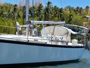 a white boat is docked in the water at Sailboat Nika, Tilly's Sail Tours in Siaton
