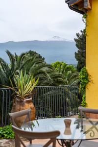 einen Tisch und Stühle auf einem Balkon mit einer Pflanze in der Unterkunft Tenuta Rustìca in Roccella Valdemone