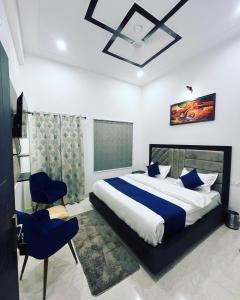 ein Schlafzimmer mit einem großen Bett mit blauen Kissen in der Unterkunft The Nines hotel & restro in Kālādhūngi
