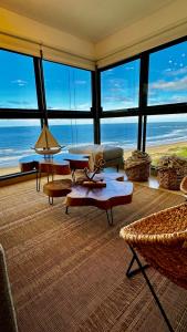 a living room with a view of the ocean at Depto FRENTE al MAR la mejor ubicación Parada 3 brava INIGUALABLE cochera gym sala de juegos parrilleros imperdible in Punta del Este