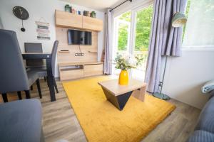 a living room with a table and a window at La Belle au Bois Normand in Litteau