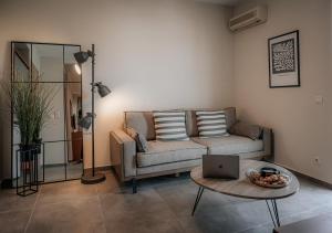 a living room with a couch and a table with a laptop at Hermes Rooms & Suites in Olympic Beach