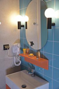 ein Bad mit einem Waschbecken und einem Spiegel in der Unterkunft Arethusa Hotel in Athen