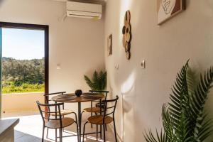 a dining room with a table and chairs and a window at ELPIS appartment in Vitalades +26 photos