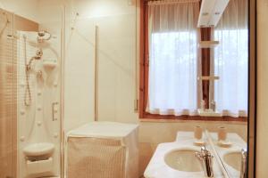 bagno bianco con lavandino e doccia di Casa Vittoria a Pietrasanta