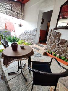 un patio con mesa, sillas y pared de piedra. en MADE in Transilvania en Sighişoara