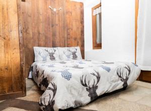 a bedroom with a bed with a deer comforter at Maison Justy in Cogne