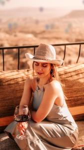 a woman in a hat holding a glass of wine at Ages in Cappadocia in Uchisar