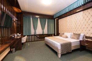 a bedroom with a bed and a desk and a bed sidx sidx sidx at Dashli Qala Hotel in Ganja