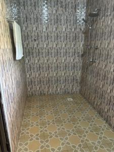 Tokuse的住宿－Nyawoyi Villa，带淋浴的浴室,铺有瓷砖地板。