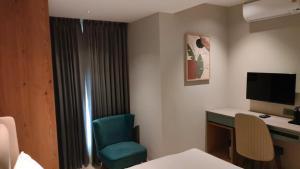a hotel room with a desk and a blue chair at Livi Suites - Premium 1 BHK Serviced Apartments in Bangalore