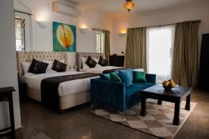 een slaapkamer met een groot bed en een blauwe stoel bij Coconut Residence & Spa in Kololi