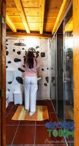 una mujer parada en un baño con una pared de vaca en O Pomar do Gasparinho, en Santa Cruz da Graciosa