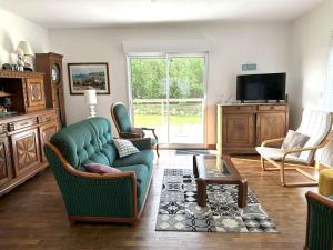 ein Wohnzimmer mit Sofa, Sesseln und Fernseher in der Unterkunft Maison *** à 500m de la mer, jardin clos, WIFI, vélos gratuits - Trégastel - FR-1-368-238 in Trégastel