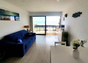 Una sala de estar con un sofá azul y una mesa. en JES holidays, en Costa da Caparica