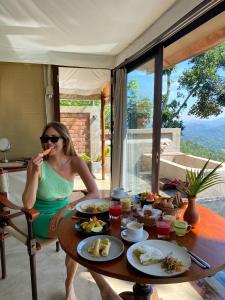 una mujer sentada en una mesa comiendo comida en Aarunya Nature Resort and Spa en Kandy