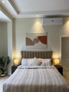 een slaapkamer met een groot bed met 2 nachtkastjes bij Halima Shared Housing - Female only in Dubai