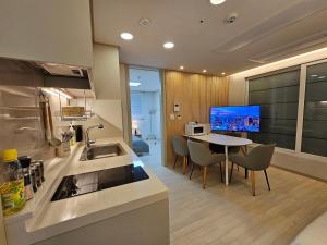 une cuisine avec un évier et une table avec des chaises dans l'établissement modern house, à Séoul