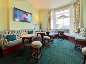a waiting room with tables and a couch at Delamere Hotel in Blackpool