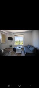 sala de estar con sofá y ventana en View Topia Apartments en Ohrid