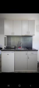 una cocina con armarios blancos y fregadero en View Topia Apartments en Ohrid