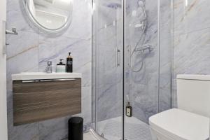 een badkamer met een douche, een toilet en een wastafel bij Finsbury Park Studios in Londen