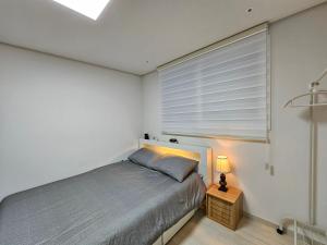 modern house في سول: غرفة نوم بسرير ونافذة بها مصباح