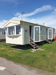 a row of mobile homes parked in a field at Arizona Caravan in Camber