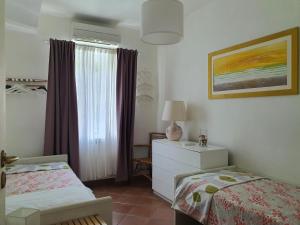 sypialnia z łóżkiem, komodą i oknem w obiekcie Paguro w Rapallo
