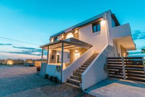 a house on the beach at dusk at Aurora 3 - Family Comfort near the beach in Marmari