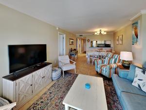 a living room with a couch and a flat screen tv at Ocean Breeze East #802 in Perdido Key