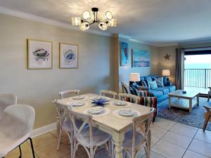 a dining room and living room with a table and chairs at Ocean Breeze East #802 in Perdido Key