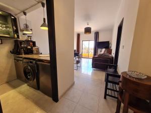 eine Küche und ein Wohnzimmer mit Waschmaschine und Trockner in der Unterkunft Beach Addiction in Costa da Caparica