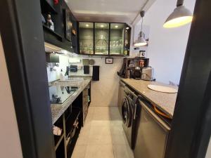 a small kitchen with a washer and dryer at Beach Addiction in Costa da Caparica