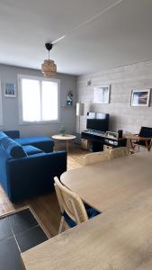 ein Wohnzimmer mit einem blauen Sofa und einem Tisch in der Unterkunft Parenthèse nantaise, charmant T2 cosy et décoré avec parking in Nantes