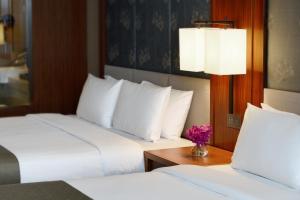 um quarto de hotel com duas camas e uma mesa com flores em Fullon Hotel Tamsui Fishermen's Wharf em Tamsui
