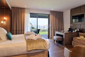 a hotel room with two beds and a desk at Hôtel Le Week end in Ajaccio