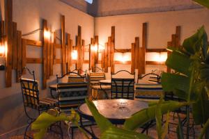 a dining room with tables and chairs and lights at Playa Del Sol Surf House in Tamraght Ouzdar