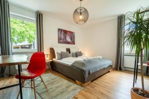 a bedroom with a bed and a red chair at dreamcation - Ehemaliges Pfarrhaus, 3D-Tour, 4 SZ, Terrasse, BBQ, Küche, Garten, 140qm in Kelheim