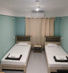 2 łóżka w pokoju z niebieskimi ścianami w obiekcie Central Hostel w Atenach