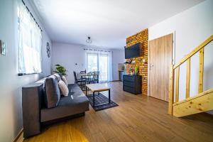 una sala de estar con un sofá y una mesa en Całoroczny Domek Bosmańska, en Lubiatowo