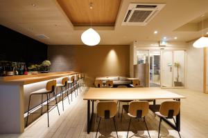 un restaurante con mesas y sillas y un bar en Nico Hotel en Osaka